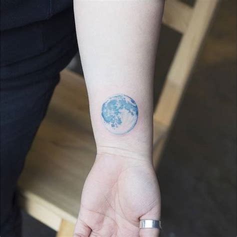 Realistic style blue moon on the wrist.