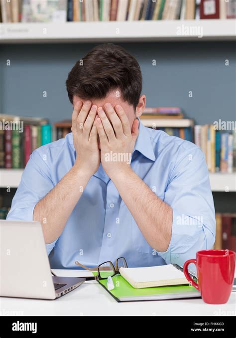 Sad student in library Stock Photo - Alamy