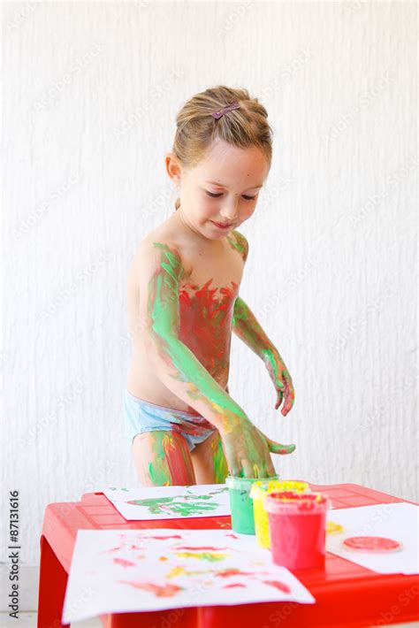 Little girl body painting herself with finger paints Stock Photo | Adobe Stock