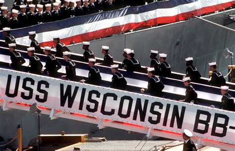 Members of the crew file aboard the battleship USS WISCONSIN (BB 64) as ...