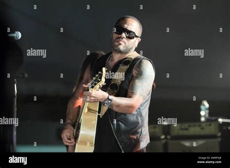 Lenny Kravitz shows off his tattoos in a sleeveless leather vest as he performs at the opening ...