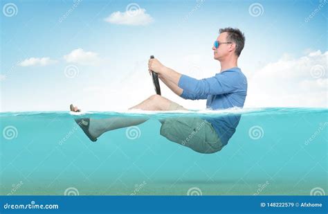 Funny Man in Sunglasses, Shorts, T-shirt and Sandals Rides on the Sea with a Car Steering Wheel ...