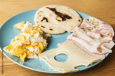 Latin american breakfast: arepa with scrambled eggs, turkey ham and ...