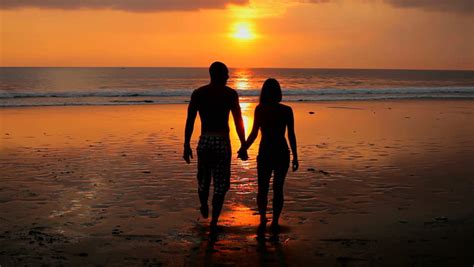 Stock Video Clip of Couple playing on beach with dog at | Shutterstock