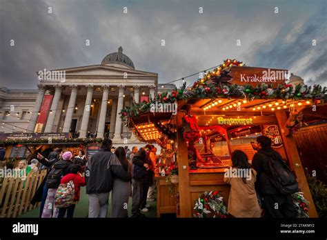 London, UK - Nov 20 2023: Trafalgar Square Christmas Market, London with people at a food stall ...