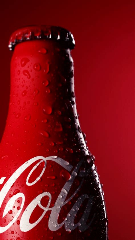 a close up of a coca cola bottle on a red background