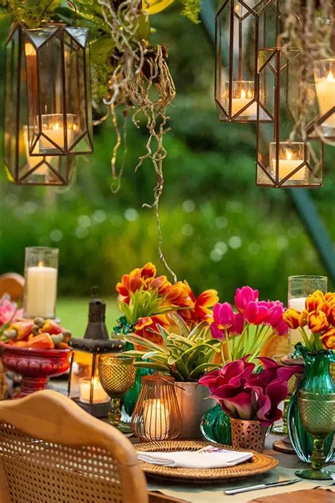 an outdoor dining table set with flowers and candles