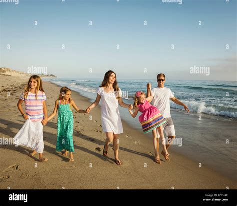 Caucasian family holding hands on beach Stock Photo - Alamy