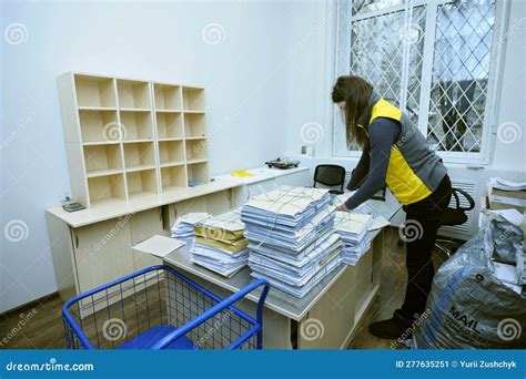 At the Post Office, Sorting Room: Woman Postal Worker in Uniform Sorting Letters and Parcels at ...