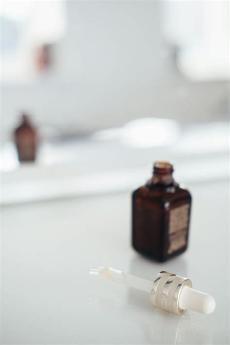 Bottle of essential oil near pipette on table · Free Stock Photo