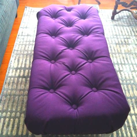 a purple ottoman sitting on top of a rug