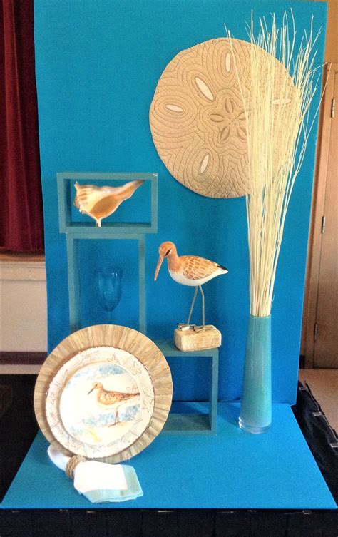 there is a blue display with birds and vases on the table in front of it