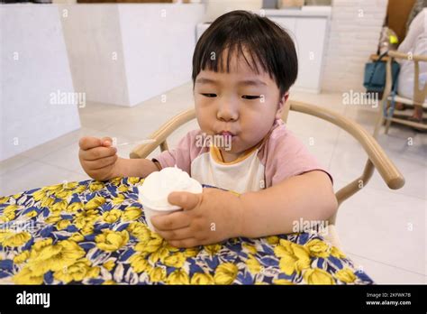 Asian little baby boy eating icecream with spoon Stock Photo - Alamy