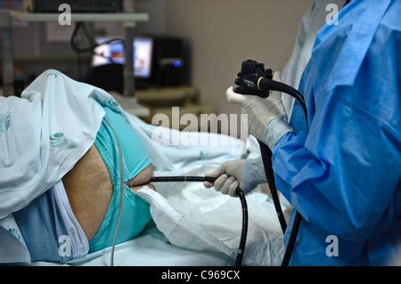 Doctor operating an endoscope to perform a colonoscopy examination procedure on a patient Stock ...