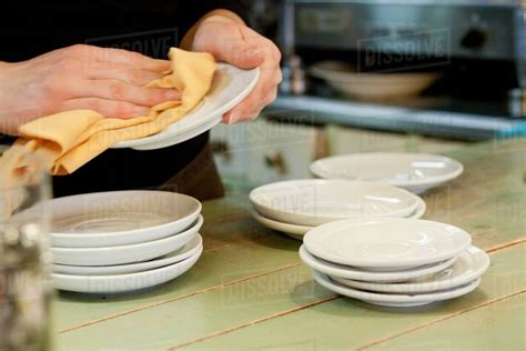 Hands drying dishes in kitchen - Stock Photo - Dissolve