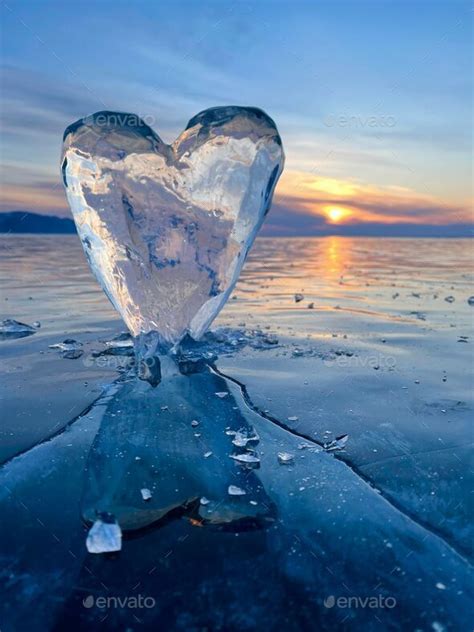 Closeup of a heart-shaped ice piece pierced into a frozen surface of a ...