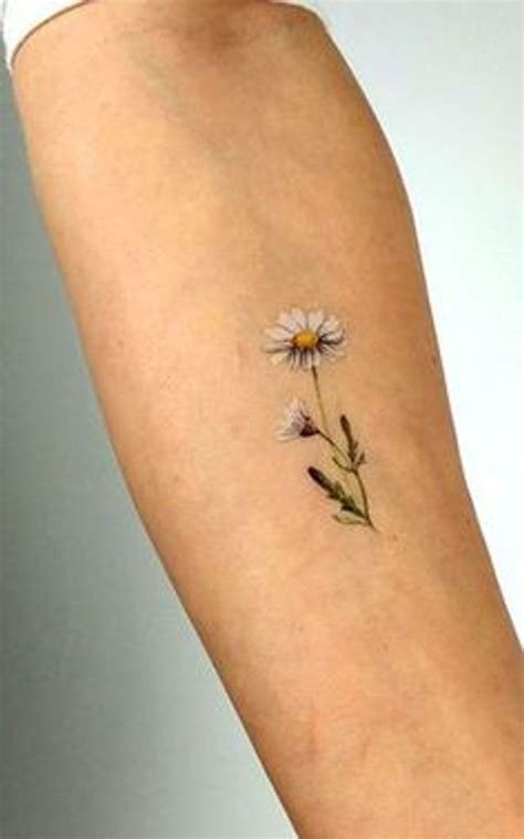 a small daisy tattoo on the arm