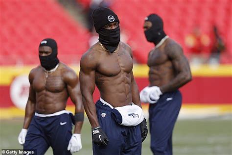 three black men with no shirts on and one wearing a face mask