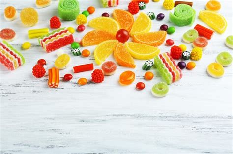 Premium Photo | Colorful candies on wooden background