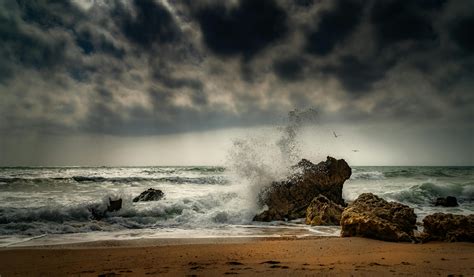 Ocean Waves Crashing on Brown Rock Formation Under Gray Clouds · Free ...