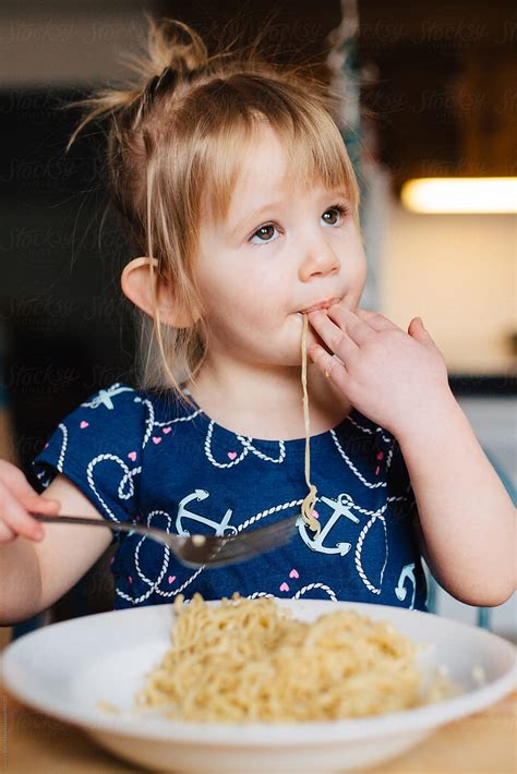 "Cute Toddler Girl In Blue Dress Eating Ramen Noodles At The Kitchen Table." by Stocksy ...