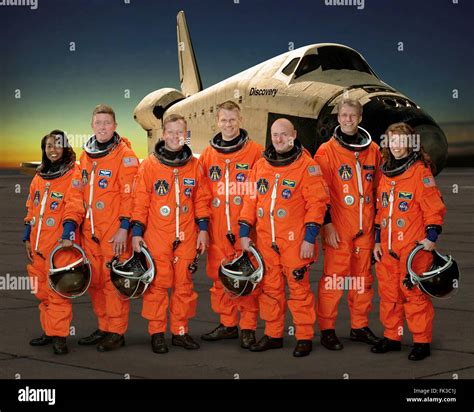 Group portrait of the STS-121 space shuttle crew astronauts in orange ...