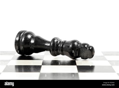 Fallen king in a chess game showing game over Stock Photo - Alamy