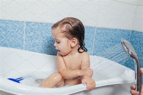 Beautiful little girl taking a bath stock photo containing bathtub and | People Images ...