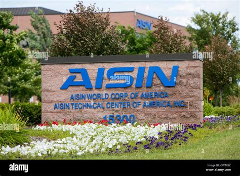 A logo sign outside of a facility occupied by Aisin Seiki Co., Ltd., in ...