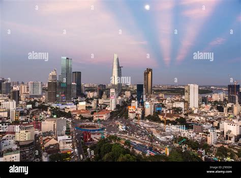 HO CHI MINH CITY, VIETNAM: The sun sets over the Ho Chi Minh City skyline that mix the colonial ...