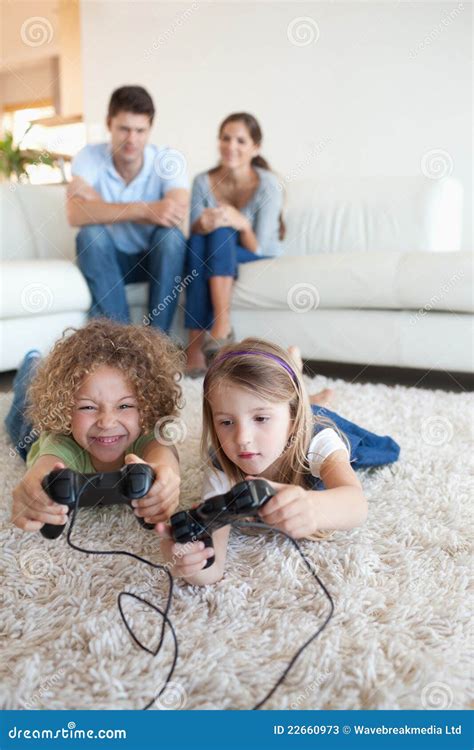 Portrait Of Children Playing Video Games While Their Parents Are Stock Photos - Image: 22660973