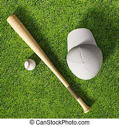 Baseball bat and ball on grass near field stripe. A selective focus view of a baseball bat and ...