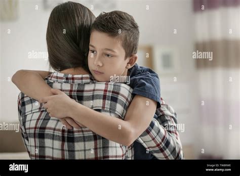 Sad little boy hugging his mother at home Stock Photo - Alamy