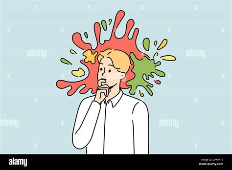 Pensive young male employee or worker with colorful splashes in head ...