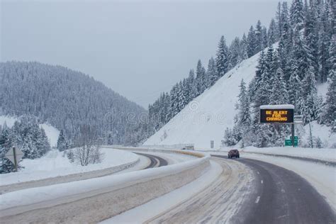 Snow-covered Highway among the Mountains, on the Sides There are Trees ...