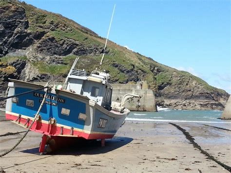 A fishing boat in Port Isaac Harbour, Cornwall, on a beautiful day ...