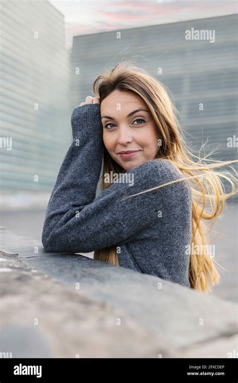 Beautiful woman smiling at retaining wall Stock Photo - Alamy
