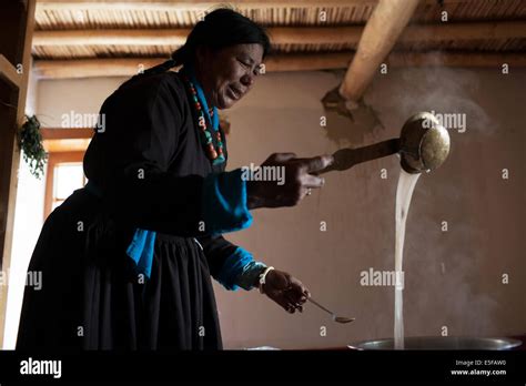 A Ladakhi women in traditional dress making Tibetan butter tea Stock ...