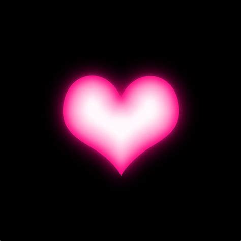 a pink heart on a black background with the light reflecting off it's side