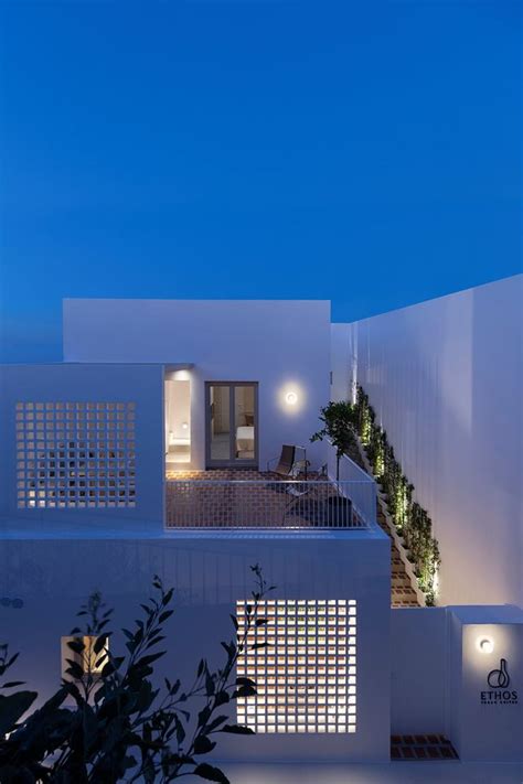 an exterior view of a modern house with white walls and lighting on the ...