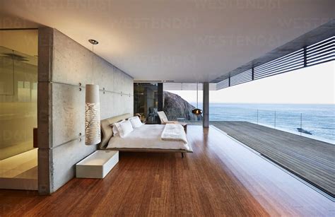 Modern luxury bedroom open to patio with ocean view stock photo