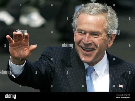 President George W. Bush waves at onlookers as he arrives at Prestwick airport in Scotland for ...