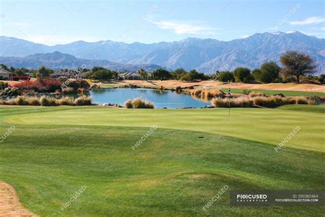 Amazing green lawn at golf course and scenic mountains on horizon at sunny day — Local Landmark ...