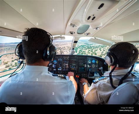 Two pilots in the cockpit, controlling the small aircraft Cessna 406 ...