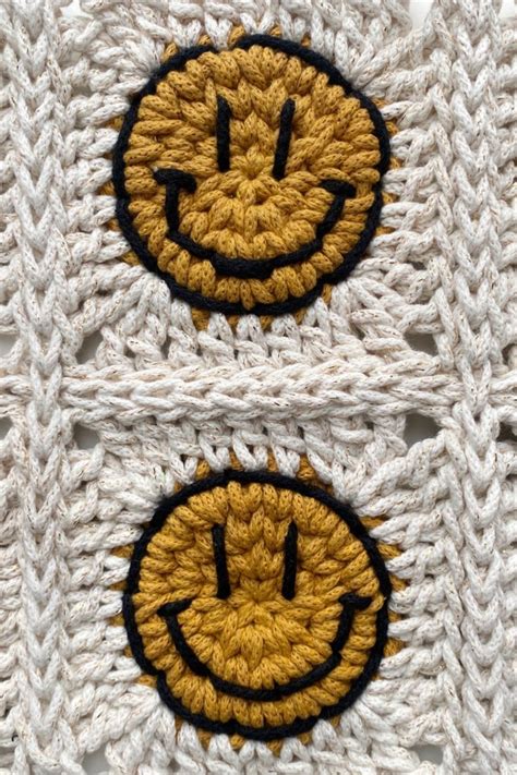 two crocheted smiley face patches on top of each other