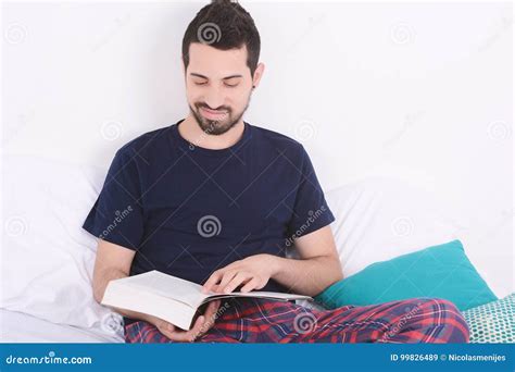 Man reading a book in bed. stock image. Image of adult - 99826489