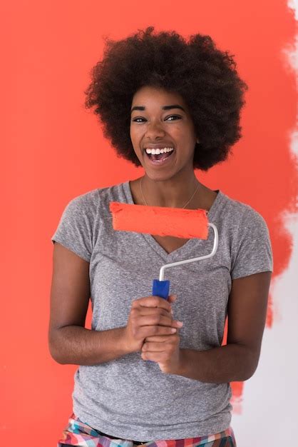 Premium Photo | Portrait of a young beautiful african american woman painting wall in her new ...