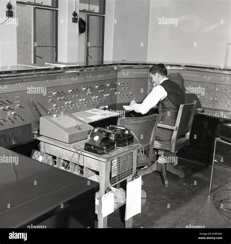 1950s, historical, male railway signal operator sitting at the control ...