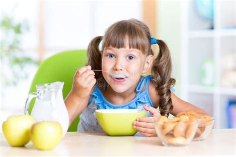 Cute Little Girl Eating Cereal with Milk in Stock Photo - Image of dish ...