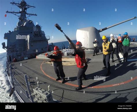 USS Carney (DDG-64) Gunner's Mate firing shot line during underway replenishment 160202 Stock ...